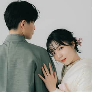 若いカップルが和装で向かい合っており、女性が微笑みながら男性の肩に寄り添っている。